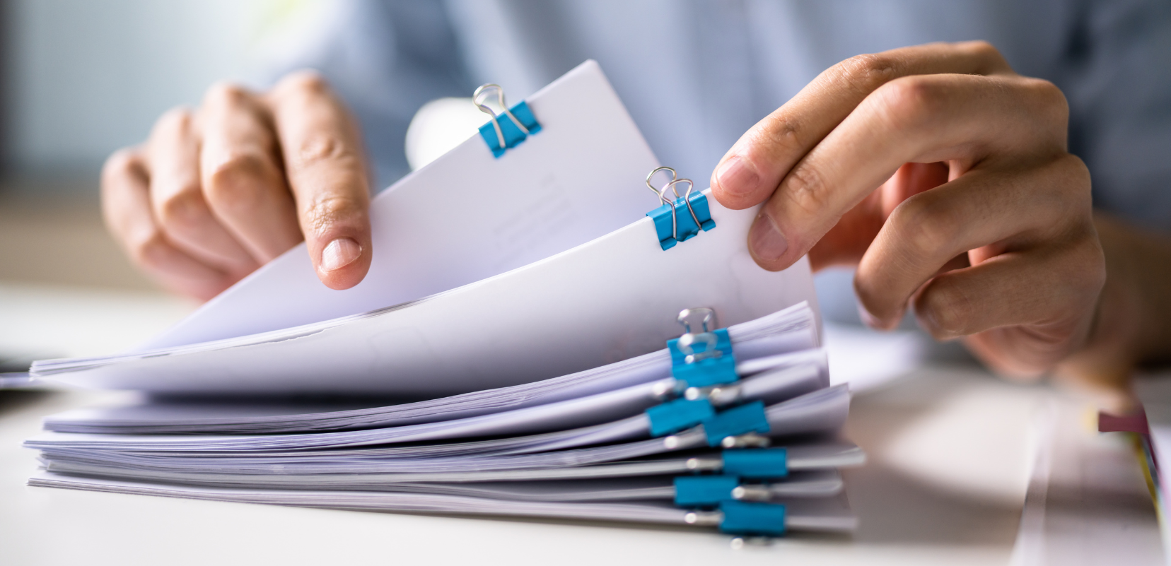 Osoba przeglądająca dokumenty związane z oceną modelu współpracy i umów cywilnoprawnych.