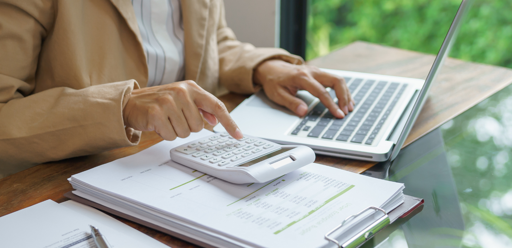 Przedsiębiorca analizuje dokumenty finansowe i oblicza jak obniżyć wpłaty na PFRON.